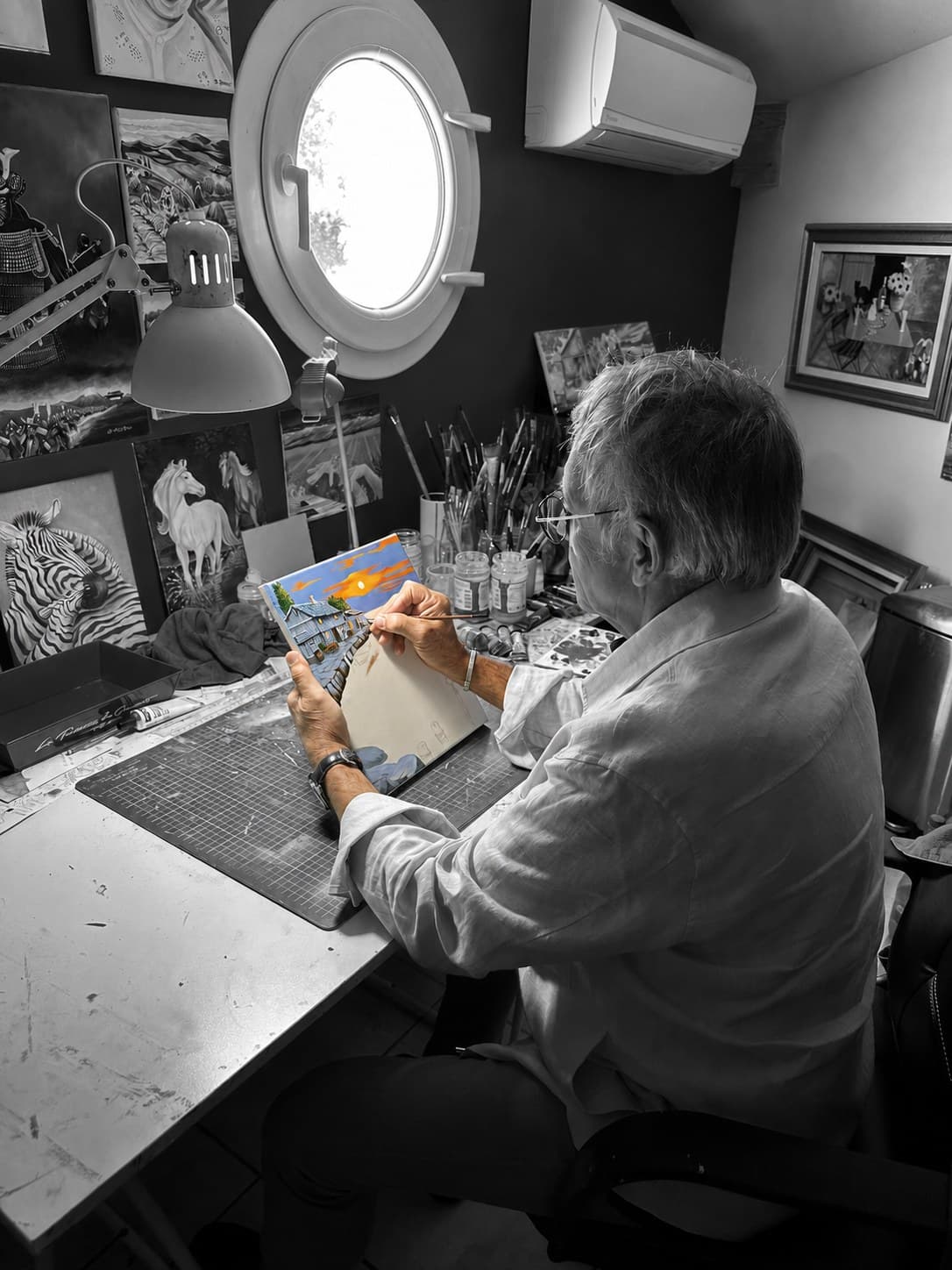 Didier Breteau at work in his studio, painting by the round attic window